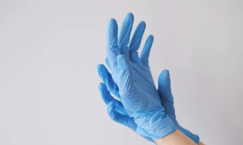 Person wearing blue gloves