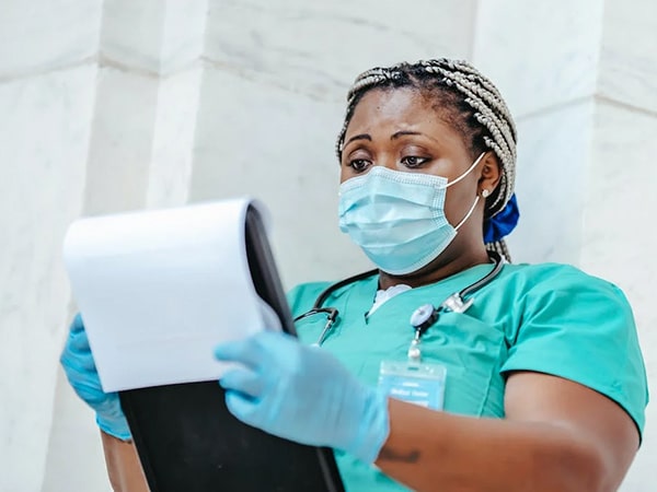Physician in sterile mask reading document