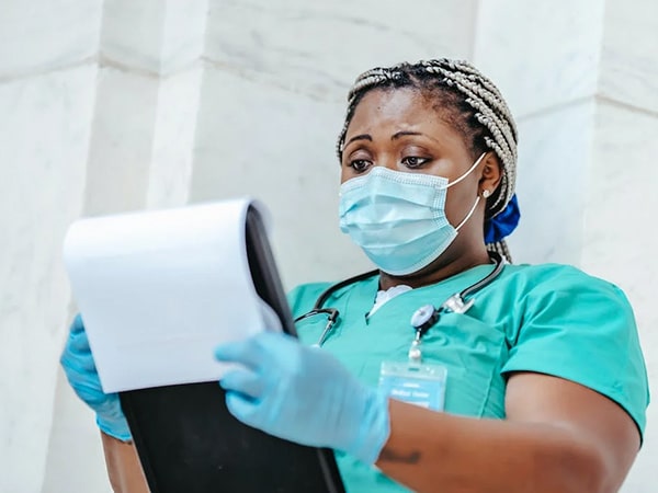 Physician in sterile mask reading document